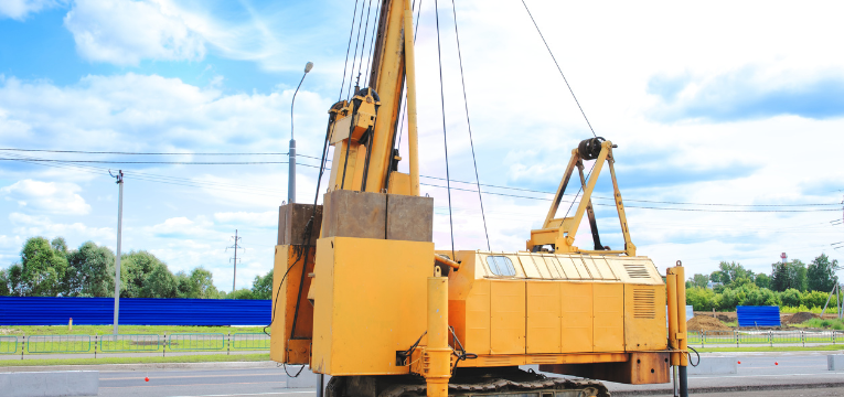 yellow pile driver on a construction site