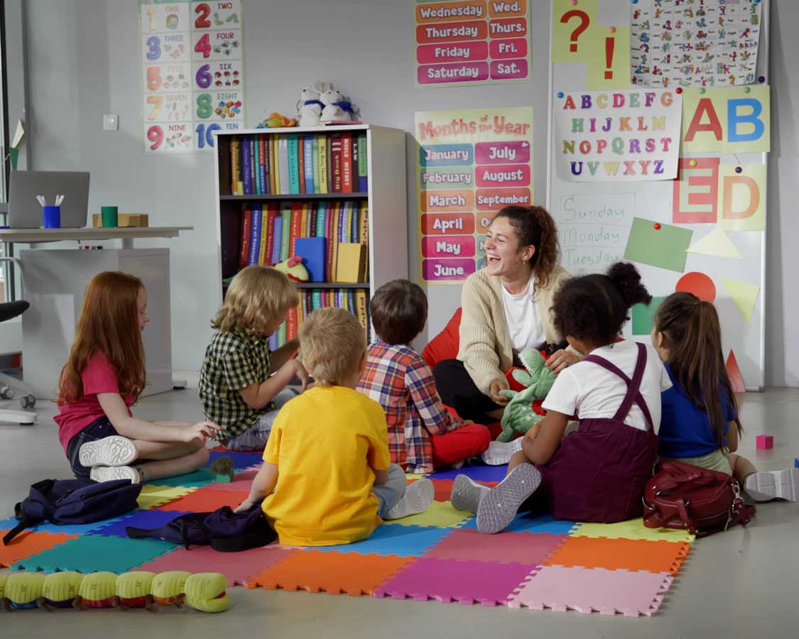 teacher with group of kids on colorful square mats
