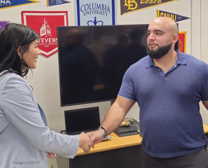 Elizabeth Rocha, left, a Green & Gold congressional aide for U.S. Rep. Lou Correa, exchanges a challenge coin with Tyler Rodriguez, vice president of Santiago Canyon College’s Student Veterans of America chapter. (Photo courtesy of RSCCD Communications)
