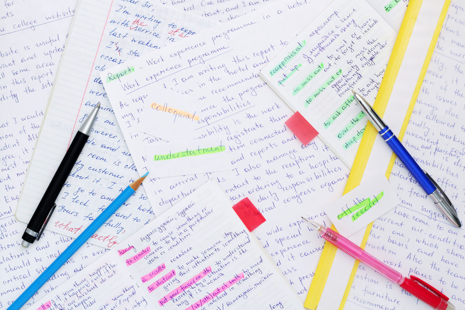 english papers on a desk with highlighters