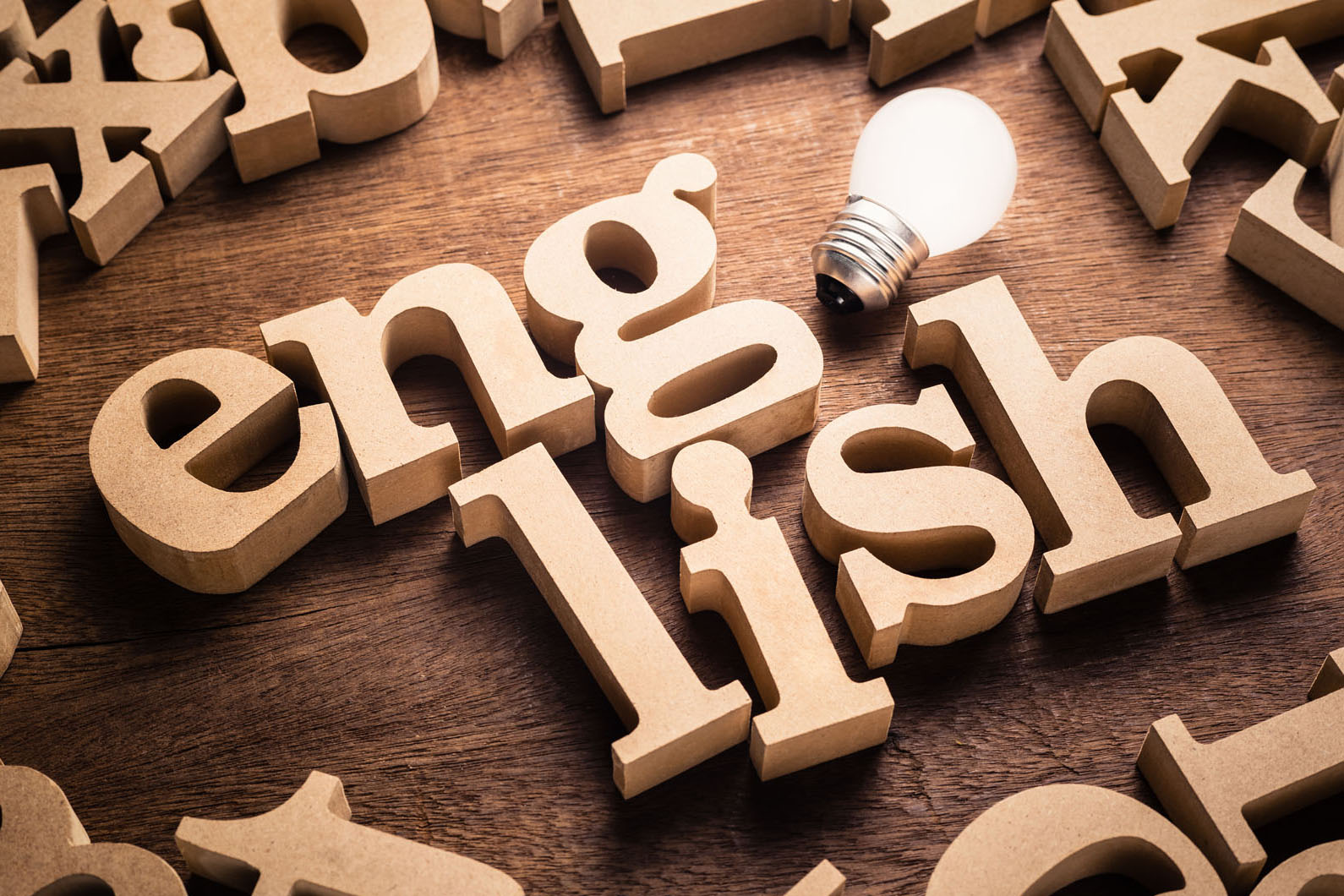 english in wooden block letters and a light bulb