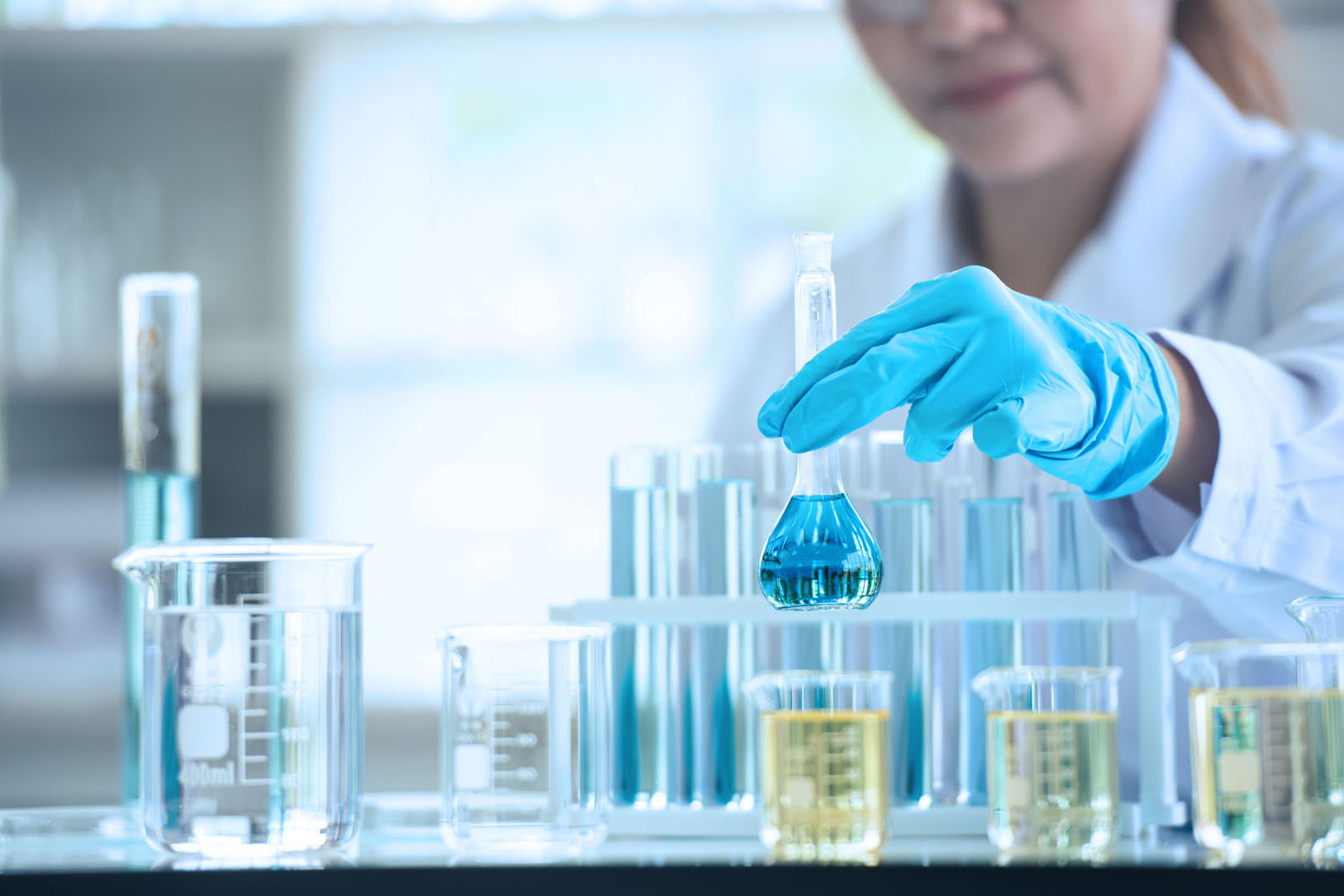 lab tech with test tubs of colored liquid