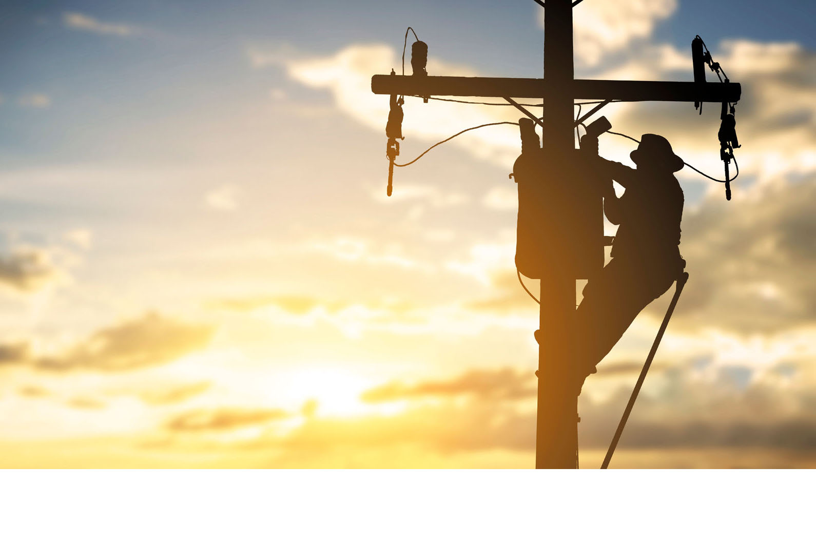 Lineman on a powerline during sunset