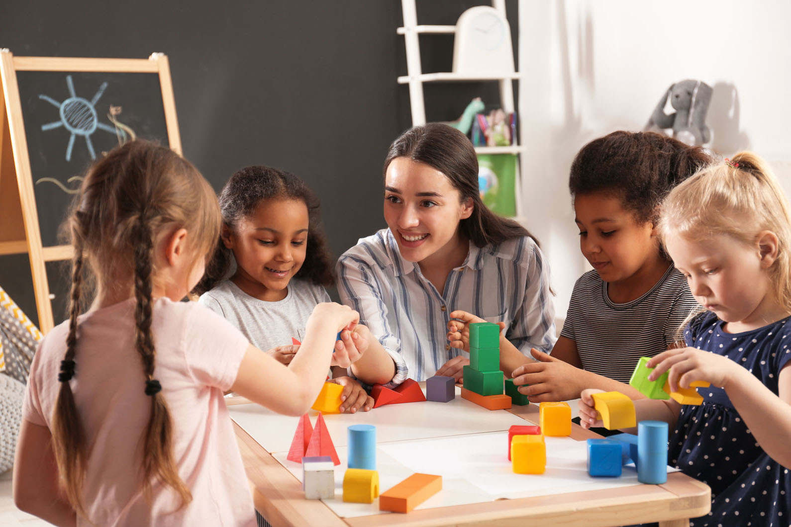 female teacher working with a group of young children